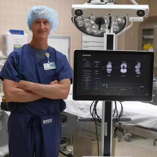 Gundersen orthopedic surgeon standing next to robotics system.